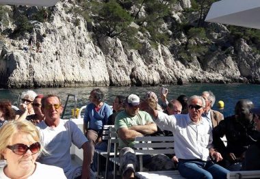 Groupe de bénéficiaires assis sur un bateau dans les calanques de Cassis.